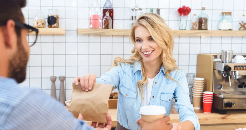 Dependienta atiende personalmente a un cliente mientras CashProtect gestiona el efectivo